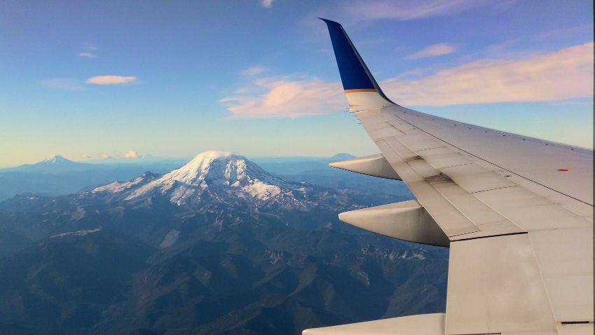 The view from the window seat of an airplane as it flies past Mount Rainier in Washington State